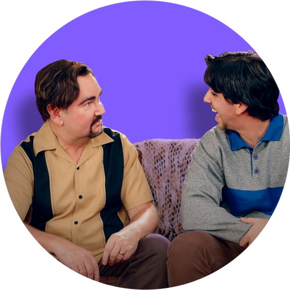 Two man sitting on a couch talking