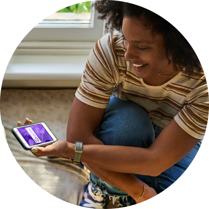 Woman crouching down on floor looking at her mobile phone
