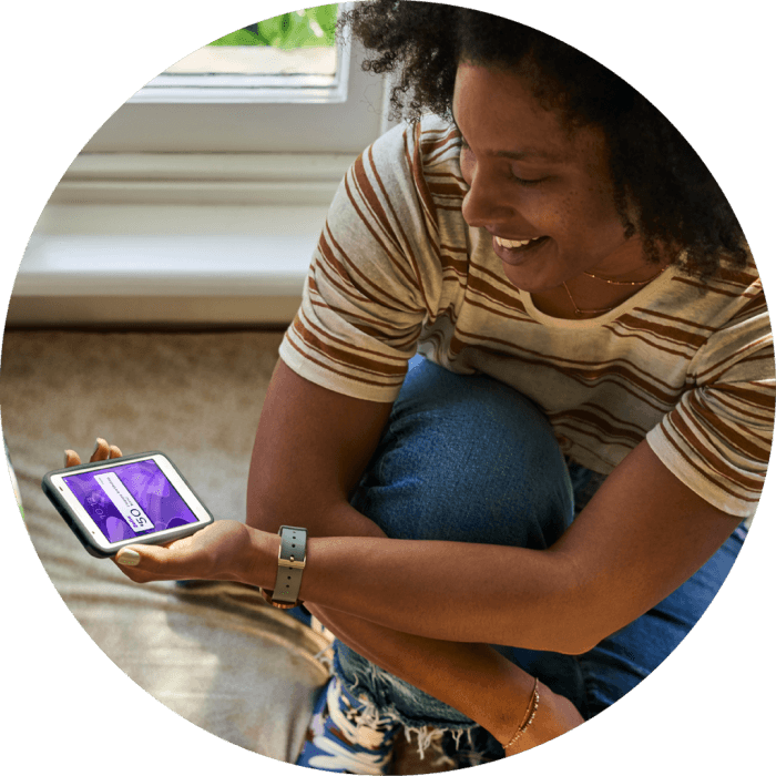 Woman crouching down on floor looking at her mobile phone.