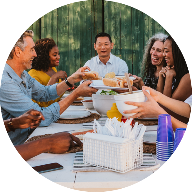 People sitting around a picnic table eating