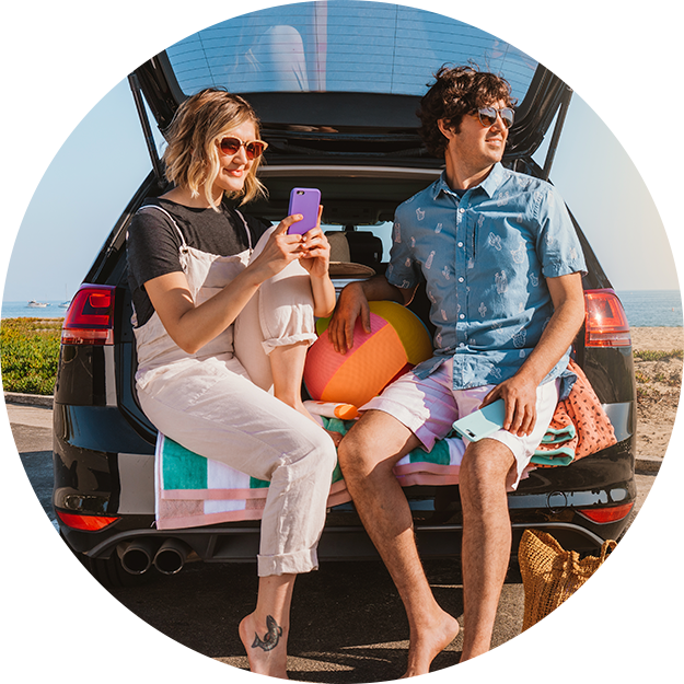 Couple sits in back of van with their phone